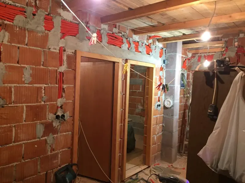 Razvod cijevi i kabela u zidu od blok opeke tijekom grubih radova